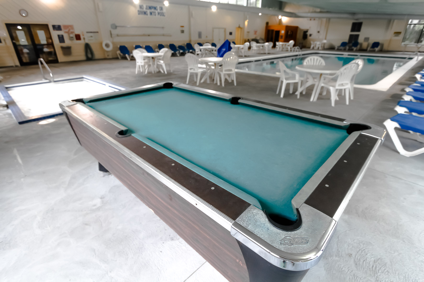 An indoor swimming pool with a pool table VRI's Sea Mist Resort in Massachusetts.